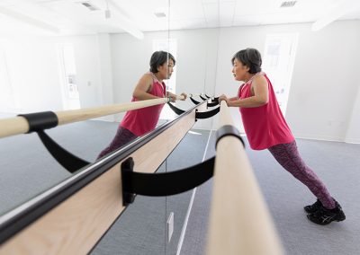 woman in mirror on ballet bar