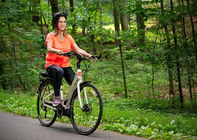 woman in orange shirt on bike