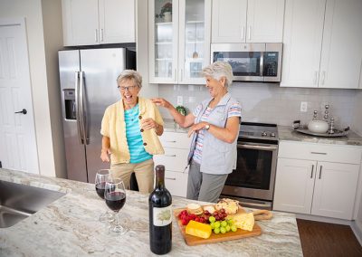 two women laughing in kitchen