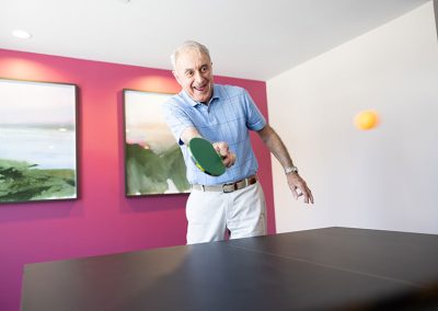 man in blue shirt playing ping pong