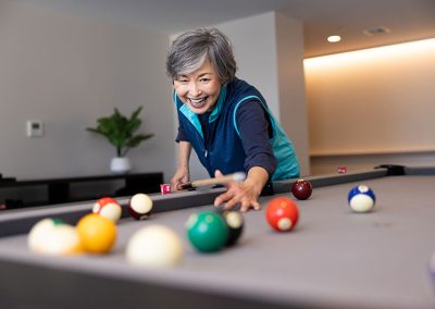 older asian woman playing pool