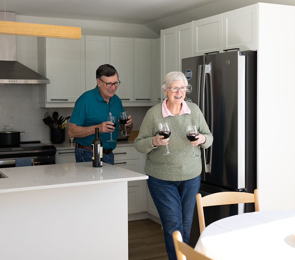 A couple in the kitchen drinking wine