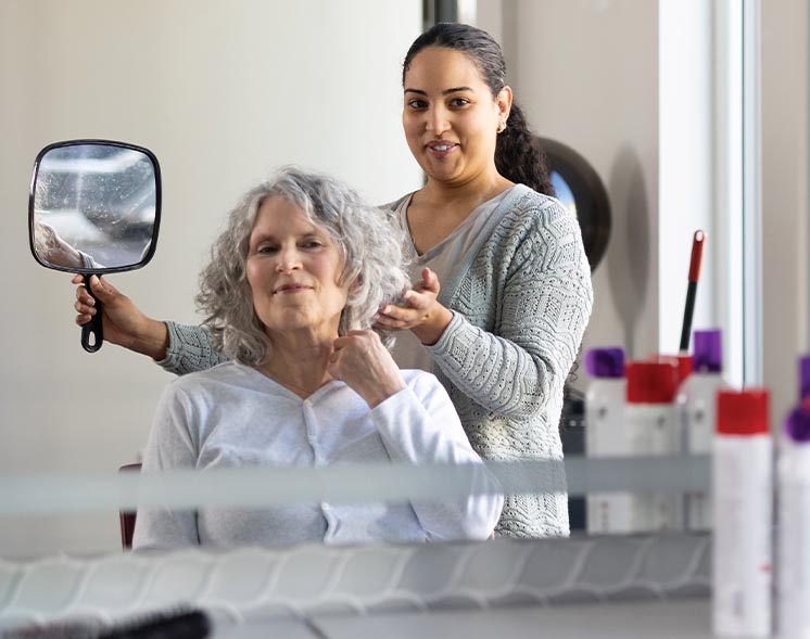 women in salon with mirror